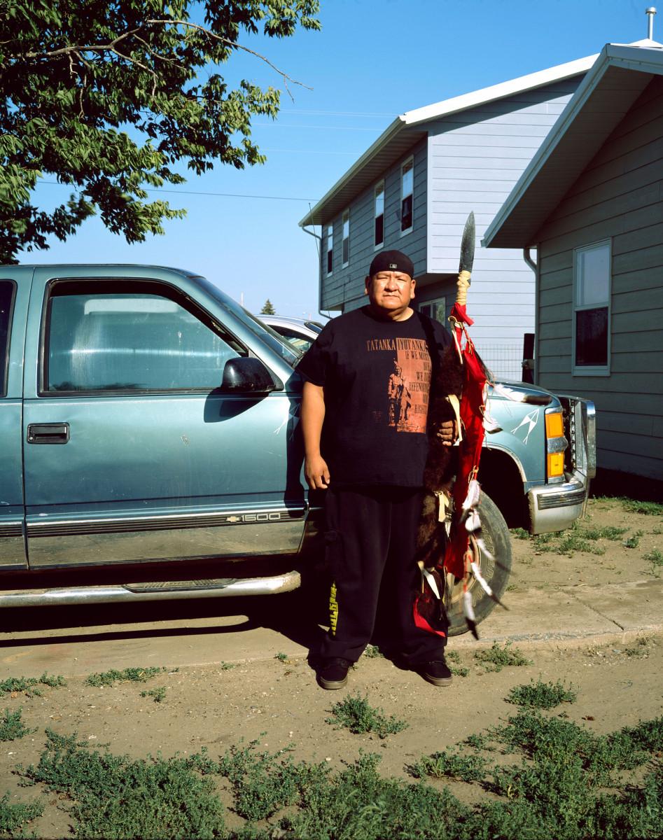 Bruno Serralongue. Gil Kills Pretty Enemy III in front of his house, posing with his weapons. McLaughlin, South Dakota, August 21, 2017. Water Protectors series, 2017, in progress. Courtesy of Air de Paris and the artist.